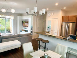 Bright open-concept living with kitchen bar &amp; balcony access